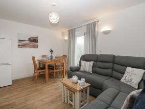 una sala de estar con un sofá y una mesa en 6 Malthouse Court, en Saint Decumans