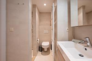 een witte badkamer met een toilet en een wastafel bij Bayaux centrum Knokke in Knokke-Heist +40 foto's