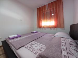 a small bedroom with a bed with a window at Apartment Ema with garage in Velika Kladuša