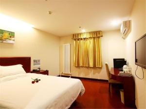 um quarto de hotel com uma cama e uma secretária com um computador em GreenTree Inn Beijing Shunyi Xinguozhan Express Hotel em Shunyi