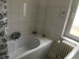 eine weiße Badewanne im Bad mit Fenster in der Unterkunft Lindas Diekblick, 2 Schlafzimmer, EG mit Terrasse in Elsfleth + 15 Fotos