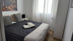 a bedroom with a bed with a blue checked blanket at Holiday, business trips in pujos in Hospitalet de Llobregat