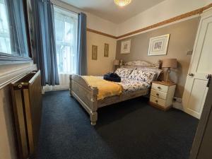 布里克瑟姆Harbour View Ground Floor Flat with Private Parking, only 5 Mins walk to harbour的带床、梳妆台和窗户的卧室