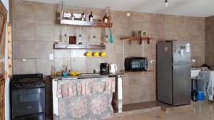 a kitchen with a refrigerator and a stove at La casa de Piscis in Termas de Río Hondo