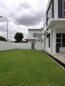 ジョホールバルにあるComfort Holiday Home @ Bukit Indahの白い建物前の大芝生