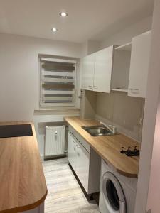 a small kitchen with white cabinets and a sink at Ferienwohnung Centro 2 in Bremerhaven
