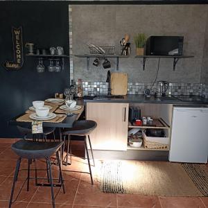 eine Küche mit Tisch und Stühlen und einer Theke in der Unterkunft Bougainvillea House in Ponta do Pargo