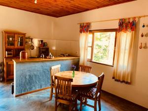 a kitchen with a table and chairs and a counter at Casa Alto do Lago - Refúgio de Paz na Mantiqueira in Gonçalves