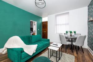 a living room with a green couch and a table at Cozy Home, Sleeps 4,Only 7mins from CENTRE, Parking, WIFI & Netflix in Killingbeck