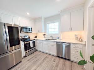 a kitchen with white cabinets and stainless steel appliances at 3001 King Suite, 3rd Floor Serenity in Surf City