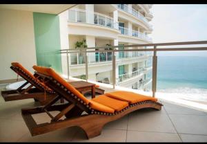 un balcon avec une chaise et une vue sur l'océan dans l'établissement Bay view Grand Marina 1104, à Ixtapa