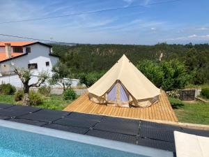 tenda situata su una terrazza accanto alla piscina di Vale Coelhos Casa de Campo a Sarnadela