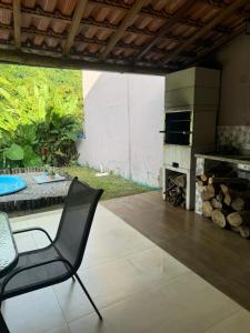 a dining room with a fireplace and a chair at Serra Mar à beira rio , rafting, suites, lofts, e Casas in Sana