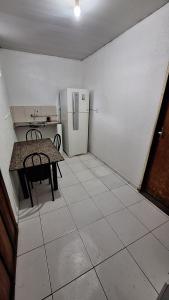 a small kitchen with a table and a refrigerator at Hospedagem simples em Manaus in Manaus