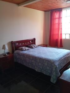 a bedroom with a bed and a red window at Casa campestre con piscina natural in Chipaque