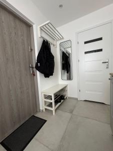 pasillo con puerta blanca y espejo en Mieszkanie na wynajem BOHO, en Lipno 4 fotos más