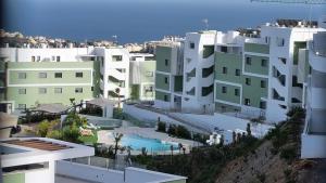 ラ・カラ・デ・ミハスにあるGarden apartment with spa, outdoor pool & parkingのスイミングプール付きの建物のアリアルビュー