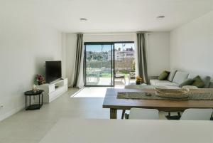 ラ・カラ・デ・ミハスにあるGarden apartment with spa, outdoor pool & parkingのソファとテーブルのあるリビングルーム