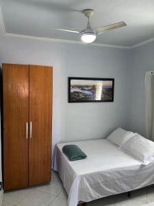 a bedroom with a bed and a wooden cabinet at Casa Branca in Saquarema +143 photos
