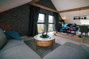 un soggiorno con un divano e una TV di Idyllic Loft Kumani Ago - Villa Rizas Hills a Traben-Trarbach