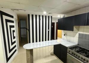 a kitchen with black cabinets and a counter top at Partition Room with window Near Mashreq Metro in Dubai