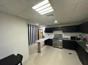 a kitchen with black and white cabinets and a sink at Partition Room with window Near Mashreq Metro in Dubai