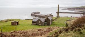 an old house on a hill next to the ocean at Omega Apartment - 3 Bedrooms - Sleeps 5 in Whitehaven