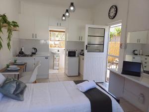 a bedroom with a large bed and a kitchen at Studio 12 in Strand