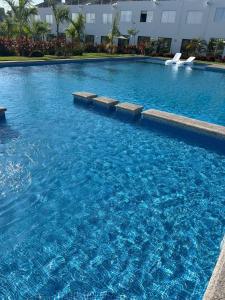 a large swimming pool with blue water in a building at Casa Monstera Bahia in Naranjo