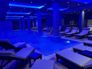 a pool in a hotel with chairs and tables at Grand Apartman Kopaonik in Kopaonik