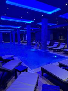 a swimming pool with tables and chairs in a building at Grand Apartman Kopaonik in Kopaonik
