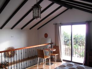 a room with a balcony with a table and a window at Fazenda do Sousinha in Funchal