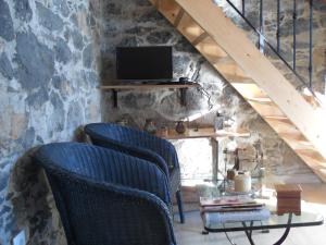 a room with three chairs and a table with a television at Fazenda do Sousinha in Funchal