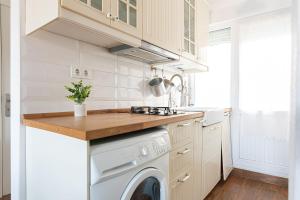 una cucina con lavatrice e lavandino di Acogedor apartamento junto a la playa a Suances