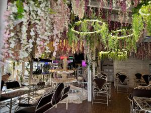 ein Raum mit Tischen, Stühlen und Blumen in der Unterkunft Viktoriya Family Hotel Restaurant complex in Kiew