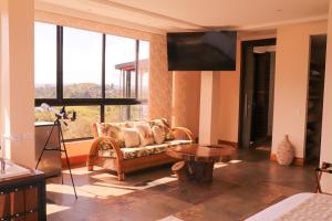 a living room with a couch and a large window at EL NiDO HOTEL GUATAPE in Guatapé
