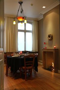 uma sala de jantar com uma mesa e cadeiras e uma janela em B&B @ Room's em Ypres