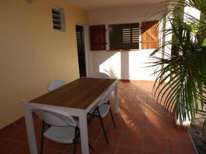 a dining room with a wooden table and chairs at LAPALOMADESANSEs in Les Anses-dʼArlets