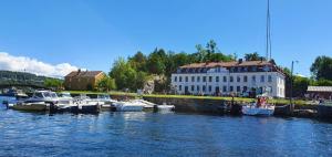 a group of boats docked in the water near a building at Villa Thorse in Husvik