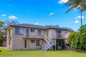 a house with a staircase and palm trees at Waterways in North Haven