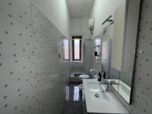 a bathroom with a sink and a toilet and a mirror at The Travelers House in Civitavecchia +7 photos