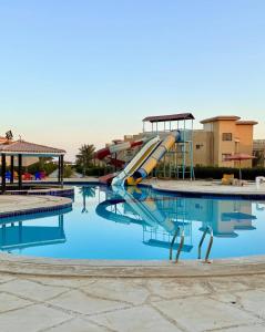 a slide in a swimming pool at a resort at First row villa on the sea in the village of Aquarius family only in Ain Sokhna