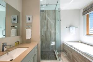 un bagno con doccia, lavandino e vasca di Clairiere 404 - Spectacular Mont-Tremblant Chalet a Mont-Tremblant Altre 19 foto