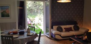 ein Wohnzimmer mit Sofa und Tisch in der Unterkunft Gîte fabuleux, jardin, terrasse, parking in Saint-Vincent-de-Mercuze