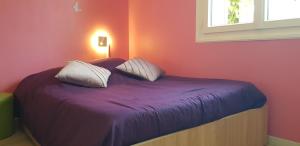 ein Schlafzimmer mit einem Bett mit violetter Bettwäsche und einem Fenster in der Unterkunft Gîte fabuleux, jardin, terrasse, parking in Saint-Vincent-de-Mercuze + 28 Fotos