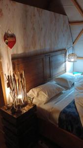 a bed with a wooden headboard in a bedroom at Domobosque in Ancud