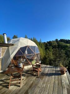 a tent on a deck with a table and chairs at Domobosque in Ancud +9 photos