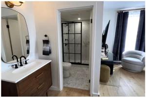 a bathroom with a sink and a toilet and a mirror at The Phenix Historic DTWN Hotel, Room # 310 in Bangor