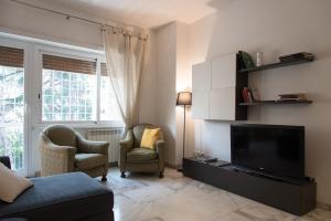 un soggiorno con TV e 2 sedie di Casa Eva - Roma a Roma