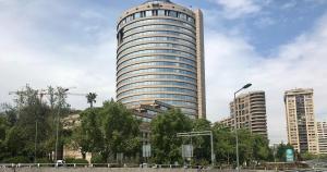 a tall building in a city with trees in front at Mirando a Parque Arauco in Santiago